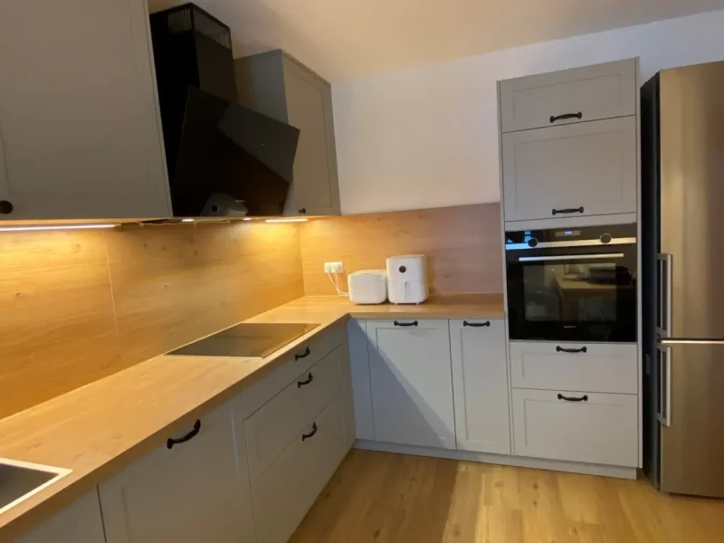 Detailbild mit Blick auf den erhöht integrierten Backofen im Hochschrank.