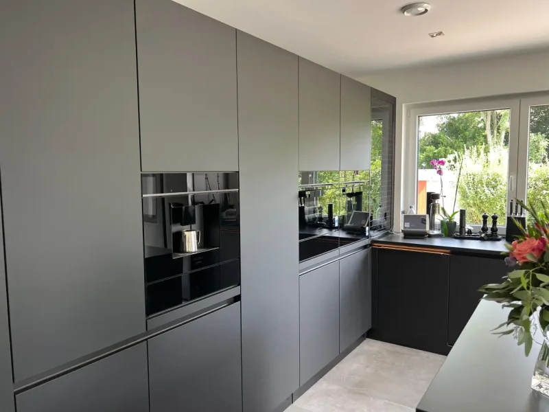 Detailansicht auf die deckenhohe Küchenzeile mit integrierten Elektrogeräten.