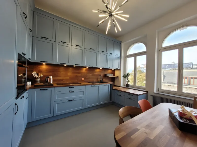 Seitliche Ansicht auf die Referenzküche mit Blick auf die großen Fenster.