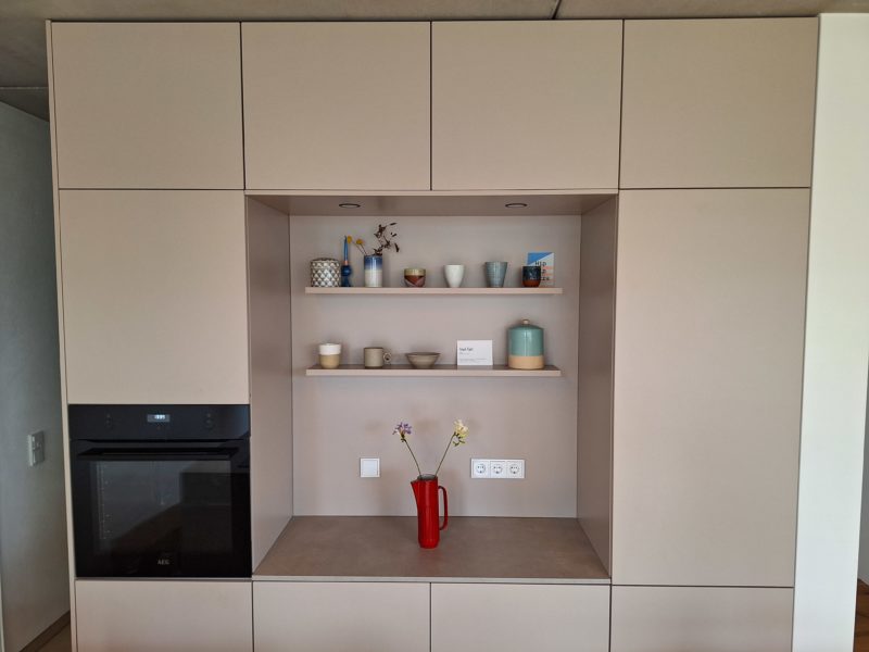 Detailansicht der Hochschrankfront mit offenem Regal und Backofen.