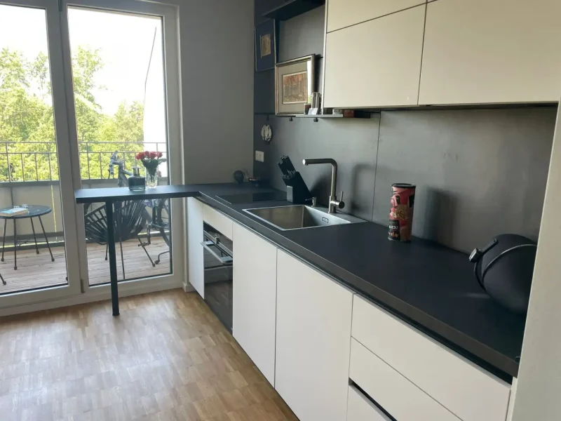 Seitliche Ansicht der hellen Küche, mit Blick auf den Balkon.