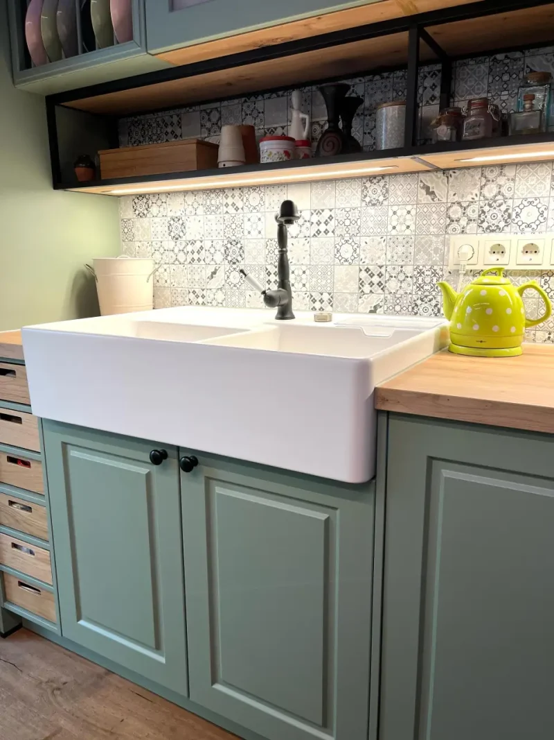 Seitenansicht des weißen Spülsteines mit dem Kontrast zu den grünen Fronten