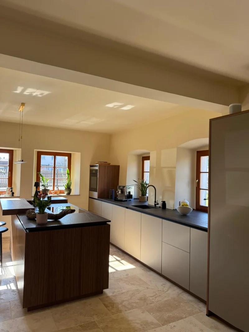 Seitlicher Blick auf die Küchenzeile und die dahinterliegenden Fenster