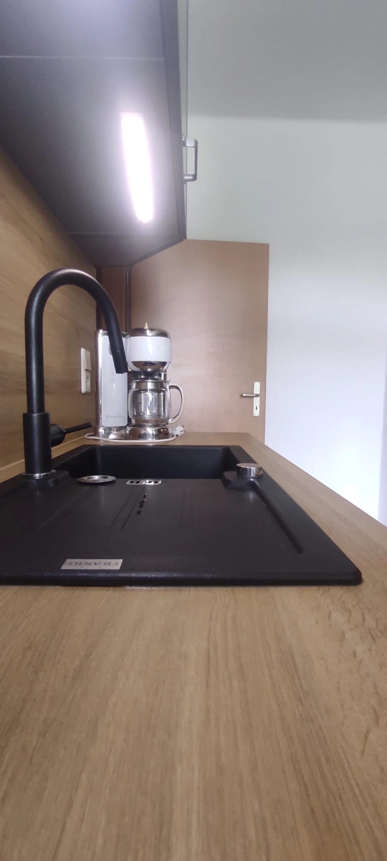 Referenzbild einer dunklen Aufsatzspüle auf einer Holz-Arbeitsplatte