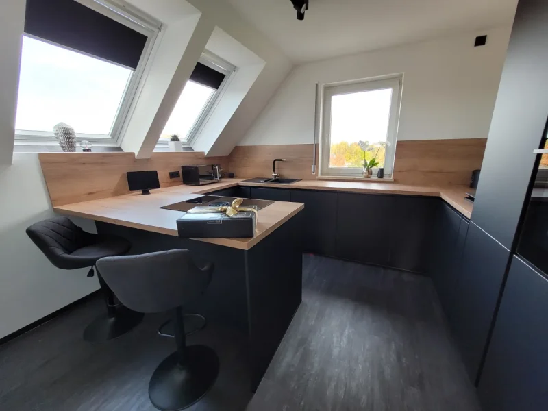 Detailansicht mit Blick auf den integrierten Sitzbereich mit zwei Barhockern an der kurzen Zeilenseite.