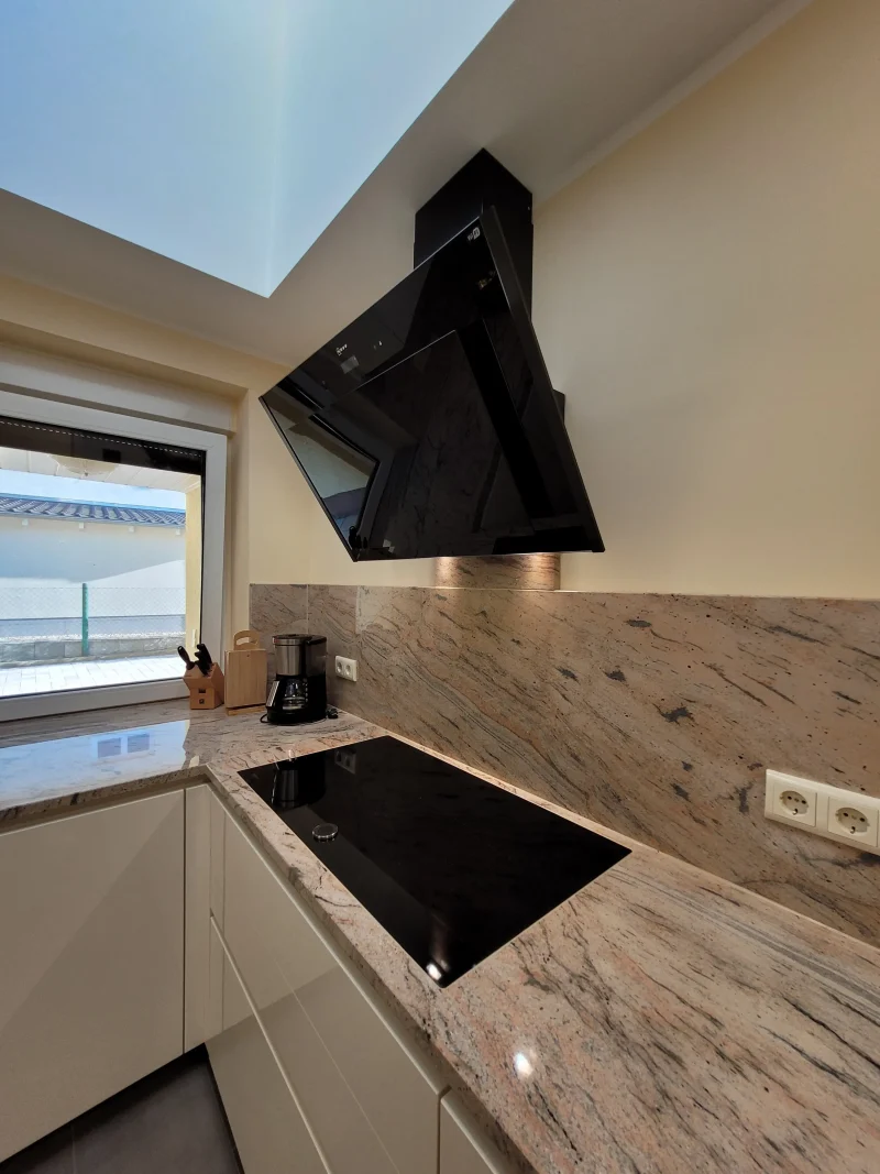 Detailansicht des Kochfeldes und der Kopf-Frei-Dunstabzugshaube.