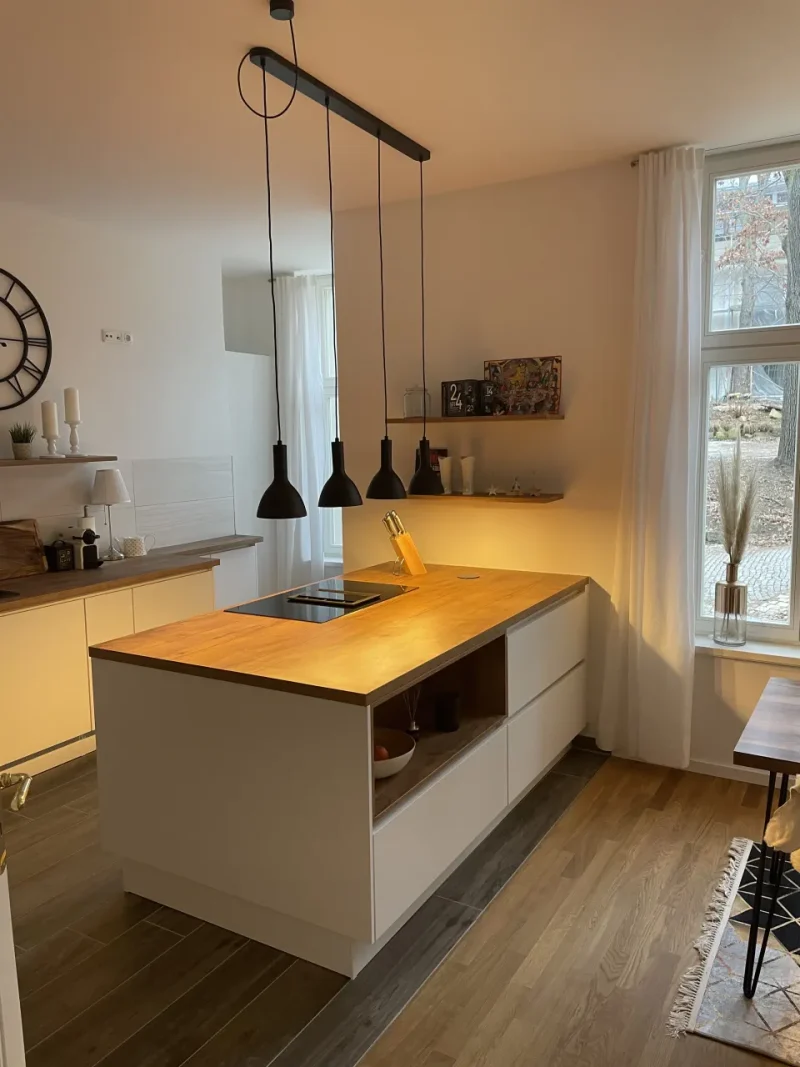 Detailansicht der Kücheninsel mit Stauraum und Kochfeld.