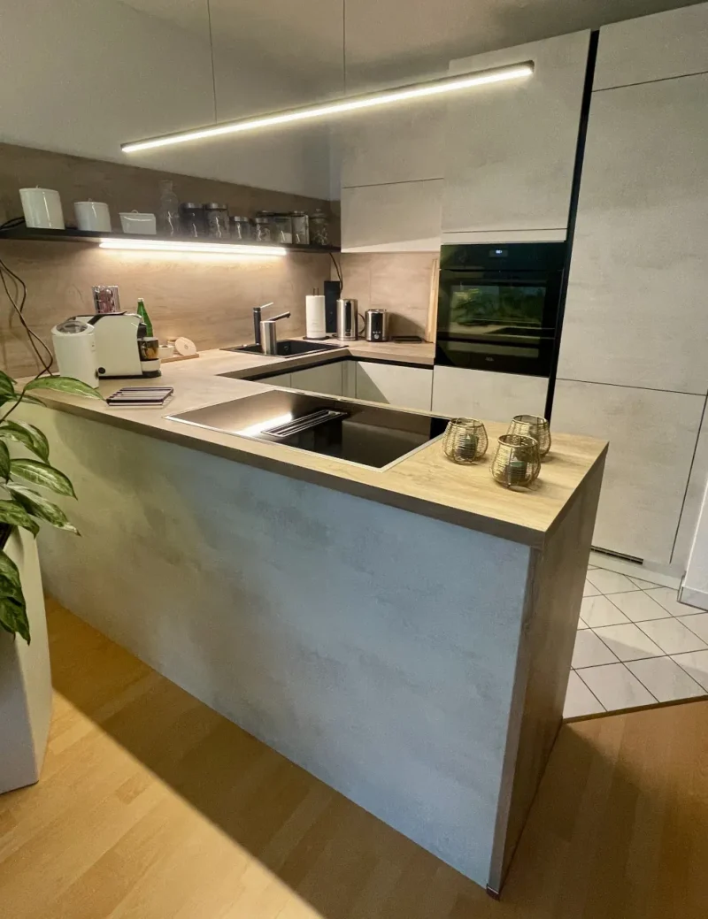 Frontaler Gesameindruck der Küche mit weißen Fronten und hellen Holzarbeitsfläche