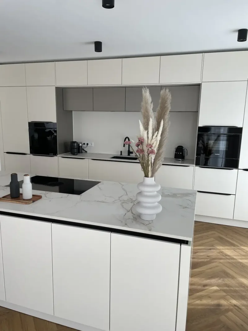 Einblick im Hochformat mit Schwerpunkt auf die Kücheninsel mit integriertem Kochfeld.