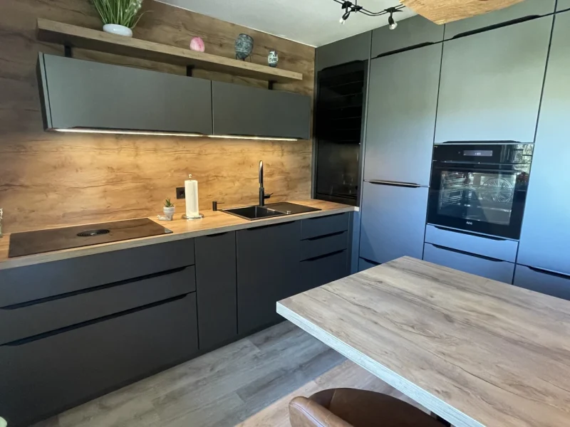 Seitenansicht der Küche mit BLick auf die beiden großen Küchenzeilen, z.T. mit Wandhohen Schränken.