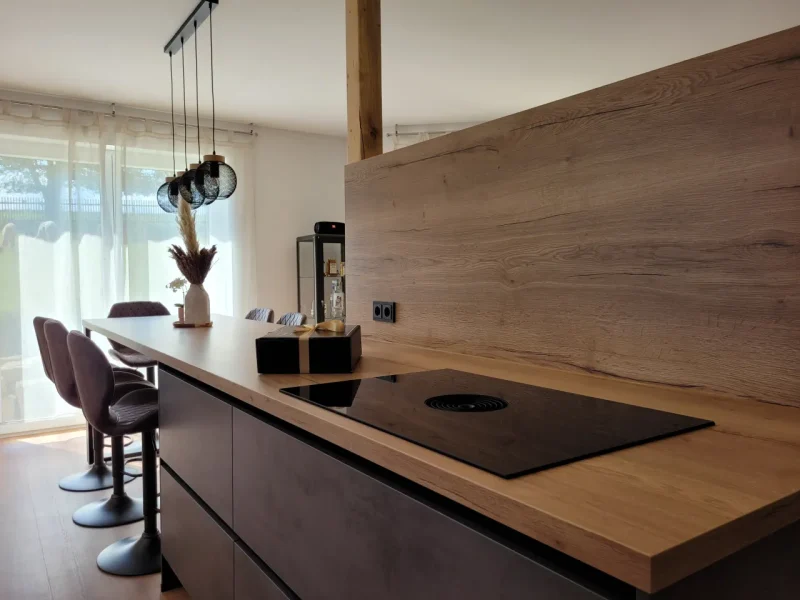 Detailbild der Küche mit Blick auf die zweite Küchenzeile mit integriertem Kochfeld mit Muldenlüfter